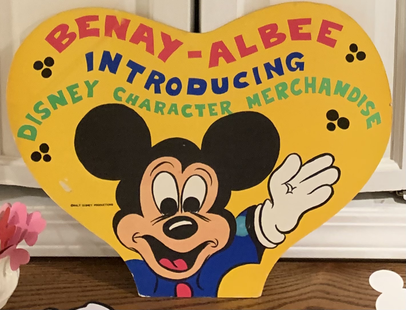 Yellow heart-shaped Benay-Albee Disney merchandise display sign featuring Mickey Mouse