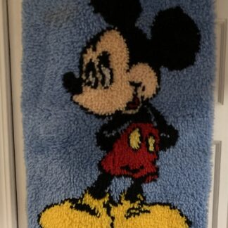 Mickey Mouse latch-hook wall hanging with a blue background, red shorts and yellow shoes